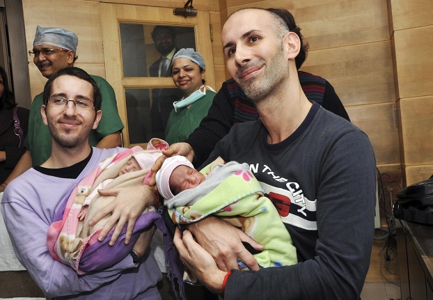 Mauro (R) and his partner Juan Carlos from Spain hold their twin babies at a private hospital after an Indian surrogate mother delivered twin baby girls for them in New Delhi February 16, 2011. Surrogate motherhood is among the latest in a long list of roles being outsourced to India, where rent-a-womb services are far cheaper than in the West. Fertility clinics usually charge $2,000-$3,000 for the procedure while a surrogate is paid anything between $3,000 and $6,000, a fortune in a country with an annual per capita income of around $500. But the practice is not without its critics in India with some calling it the "commoditisation of motherhood" and an exploitation of the poor by the rich.